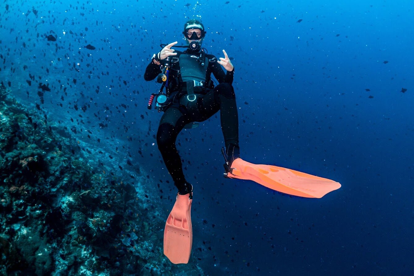 Diver in the water doing a cool sign with hands